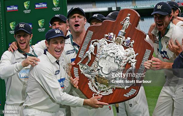 Bushrangers captain Cameron White holds the Sheffield Shield as he celebrates with his team mates after day five of the Sheffield Shield Final match...