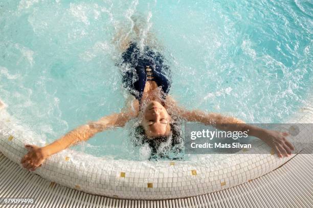 woman relaxing in a hydro massage pool - women massage stock-fotos und bilder