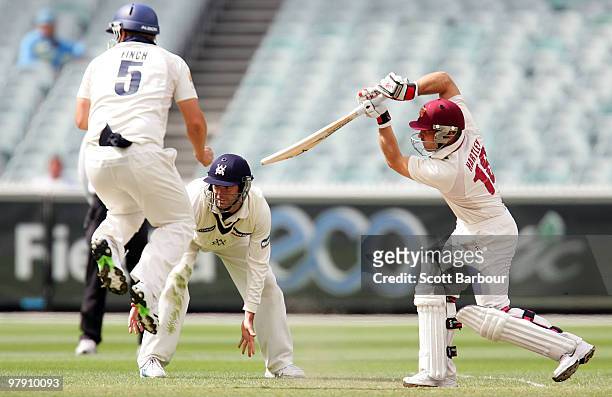 Chris Hartley of the Bulls hits a shot as Aaron Finch of the Bushranger jumps out of the way during day five of the Sheffield Shield Final match...