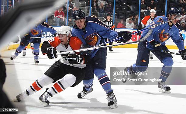 Marty Reasoner of the Atlanta Thrashers checks Darroll Powe of the Philadelphia Flyers at Philips Arena on March 20, 2010 in Atlanta, Georgia.