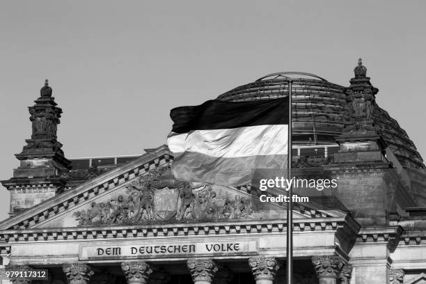 the famous inscription on the architrave on the west portal of the reichstag building in berlin: "dem deutschen volke" with german flag - architrave stock pictures, royalty-free photos & images