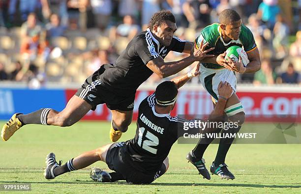 Ryno Benjamin of South Africa is tackled by New Zealand's Save Tokula and Zar Lawrence in the Adelaide Sevens rugby union, in Adelaide on March 21,...