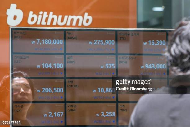 Man is reflected in a window as he looks at monitors displaying the prices of cryptocurrencies at a Bithumb exchange office in Seoul, South Korea, on...