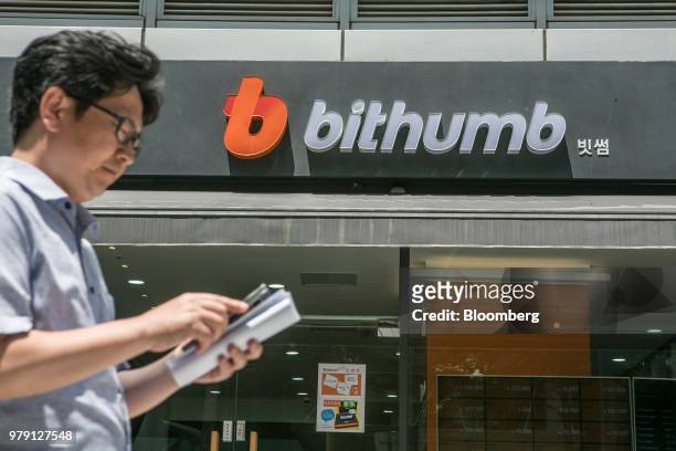 Signage for Bithumb is displayed at an exchange office in Seoul, South Korea, on Wednesday, June 20, 2018. Virtual currencies dropped after Bithumb,...