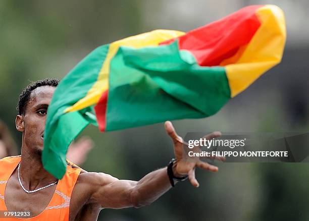Ethiopian Siraj Gena reaches for his national flag as crosses the finish line after winning the 16th Rome Marathon 'Maratona di Roma' on March 21,...