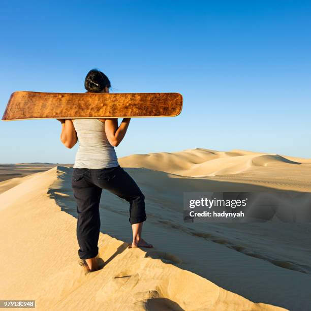 young woman sandboarding in the sahara desert, africa - western sahara desert stock pictures, royalty-free photos & images