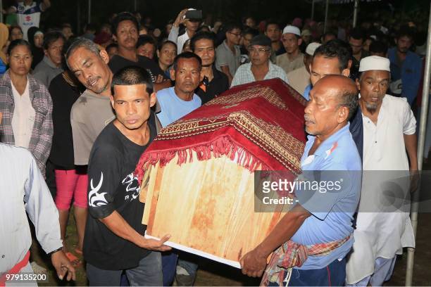 In this picture taken on June 19, 2019 shows mourners carrying the bier bearing the body of executed Thai prisoner Theerasak Longji on arrival in his...
