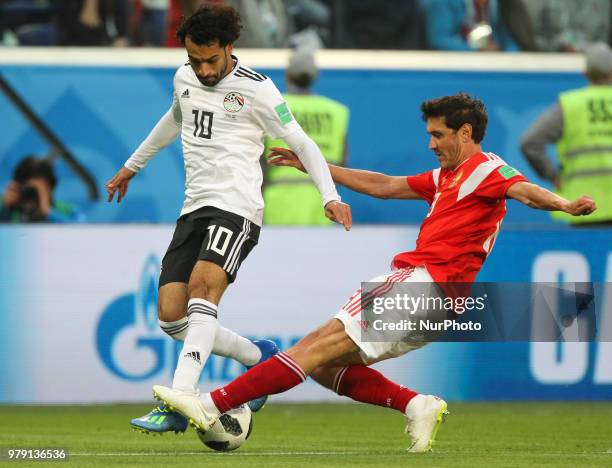 Mohamed Salah of the Egypt national football team and Yury Zhirkov of the Russia national football team vie for the ball during the 2018 FIFA World...