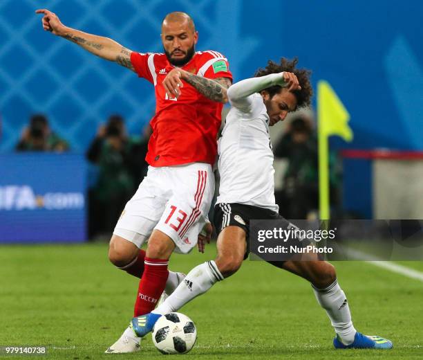 Fedor Kudriashov of the Russia national football team and Amr Warda of the Egypt national football team vie for the ball during the 2018 FIFA World...