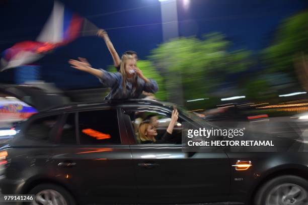 Russia's national football team fans wave flags from their car as they celebrate their team's victory in the streets of Ekaterinburg, after the...