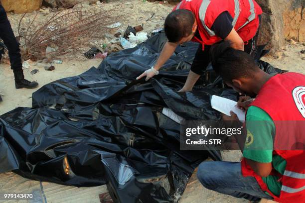 Libyan Red Crescent team members recover bodies of migrants who drowned at sea off the coast of the western city of Janzur on June 19, 2018. Libya is...