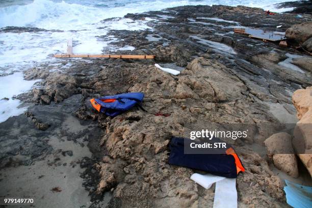 Life jackets are seen on the beach as Libyan Red Crescent team members recover bodies of migrants who drowned at sea off the coast of the western...