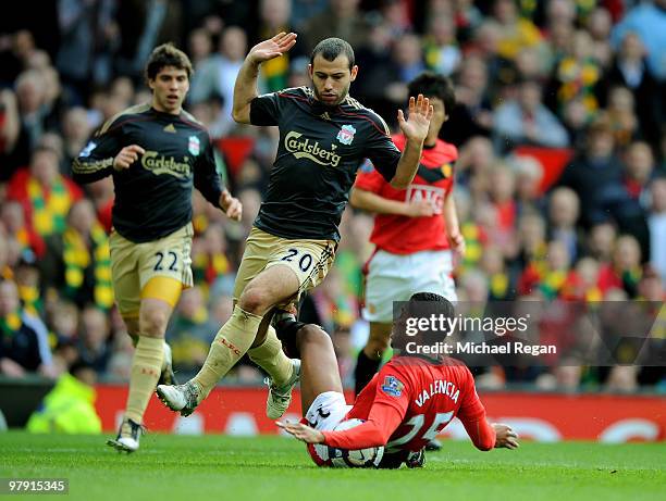 Javier Mascherano of Liverpool fouls Antonio Valencia of Manchester United and concedes a penalty during the Barclays Premier League match between...