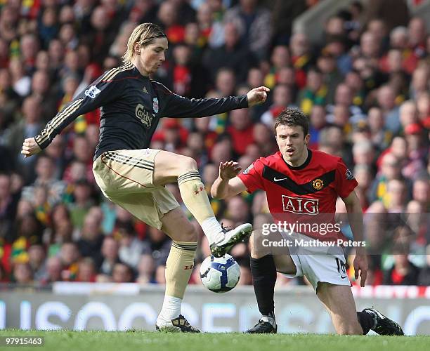 Michael Carrick of Manchester United clashes with Fernando Torres of Liverpool during the FA Barclays Premier League match between Manchester United...