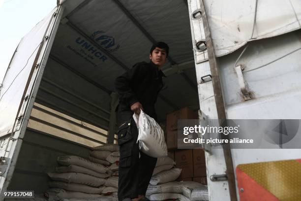 Volunteers unload aid material delivered to the rebel-held city of Douma, Eastern Ghouta province, Syria, 05 March 2018. A 46-truck convoy includes...