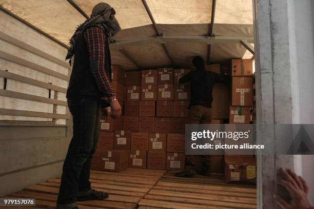 Volunteers unload aid material delivered to the rebel-held city of Douma, Eastern Ghouta province, Syria, 05 March 2018. A 46-truck convoy includes...