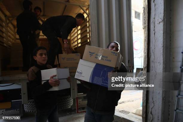 Volunteers unload aid material delivered to the rebel-held city of Douma, Eastern Ghouta province, Syria, 05 March 2018. A 46-truck convoy includes...