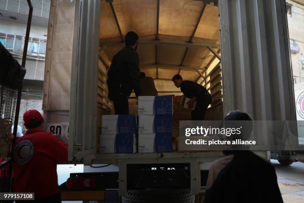 Volunteers unload aid material delivered to the rebel-held city of Douma, Eastern Ghouta province, Syria, 05 March 2018. A 46-truck convoy includes...