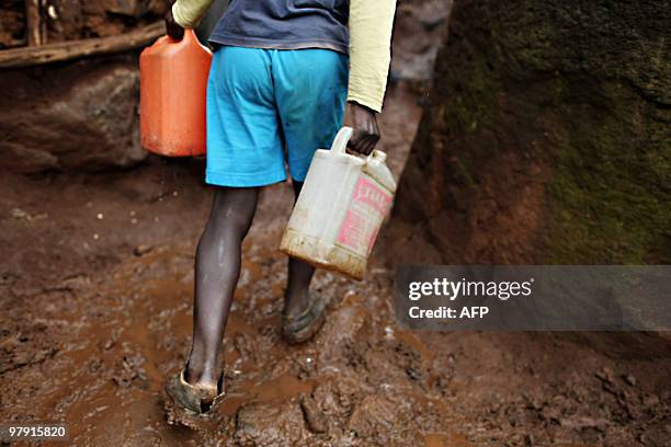 Young boy with two empty jerry cans searches for water in Kibera, the second biggest slum in Africa that is home to about 800,000 people in Nairobi,...