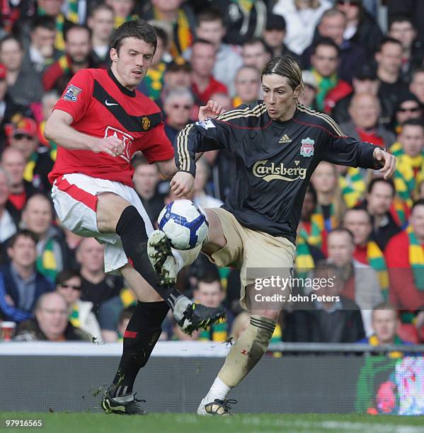 Michael Carrick of Manchester United clashes with Fernando Torres of Liverpool during the FA Barclays Premier League match between Manchester United...