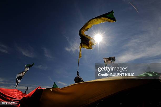 Turkish Kurds hold up Kurdish flags and chant slogan during a rally to celebrate the Kurdish New Year, known as 'Nowruz', on March 21, 2010 in...