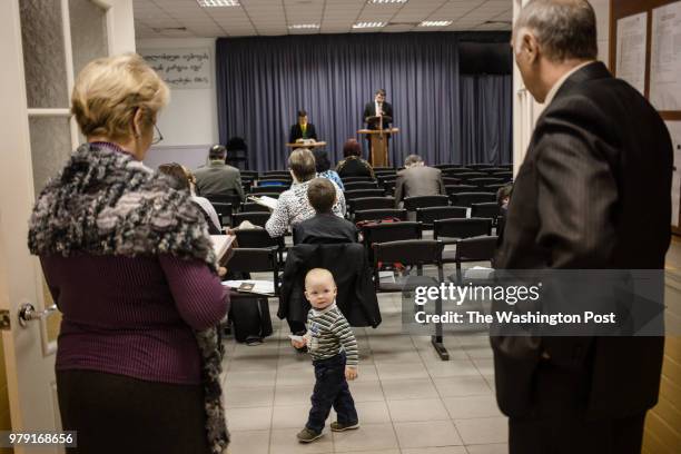 November, 2015: A little boy passes by while Jehovah's Witnesses discuss the bible. Although Rostov-on-Don is only 80 km away from Taganrog, the...