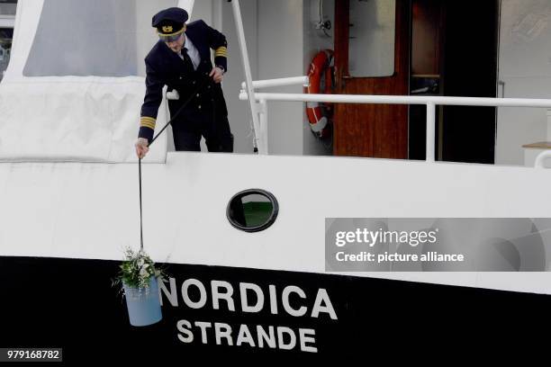 January 2018, Germany, Strande: Norman Ludwig demonstrates how an urn is let down to the water onboard his ship "Nordica". According to an estimate...