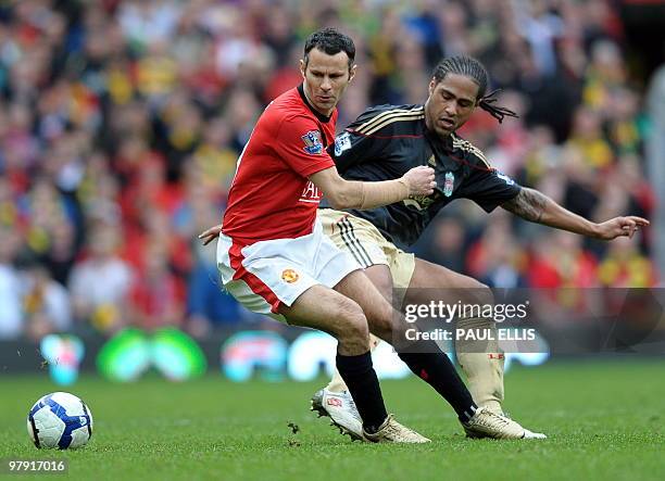 Manchester United's Welsh midfielder Ryan Giggs and Liverpool's English defender Glen Johnson compete for the ball during their English Premier...