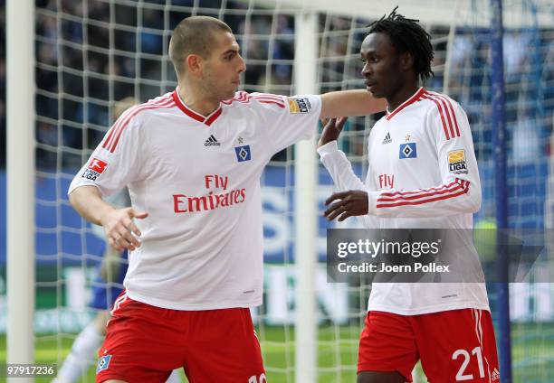 Jonathan Pitroipa of Hamburg celebrates with his team mate Mladen Petric after scoring his team's second goal during the Bundesliga match between...