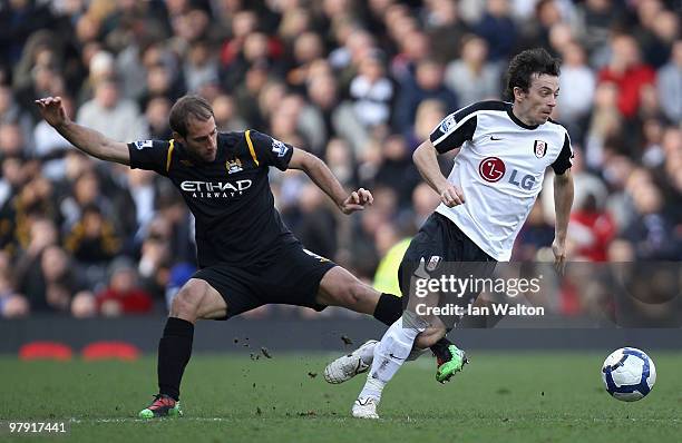 Simon Davies of Fulham is tackled by Pablo Zabaleta of Manchester City during the Barclays Premier League match between Fulham and Manchester City at...