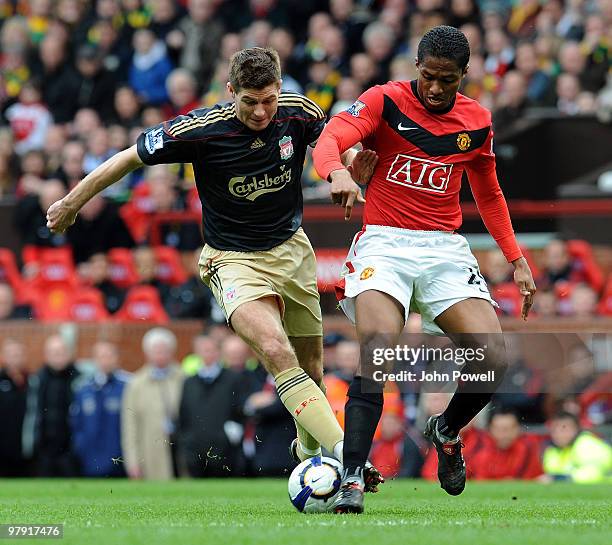 Steven Gerrard of Liverpool competes with Antonio Valencia of Manchester United during the Barclays Premier League match between Manchester United...