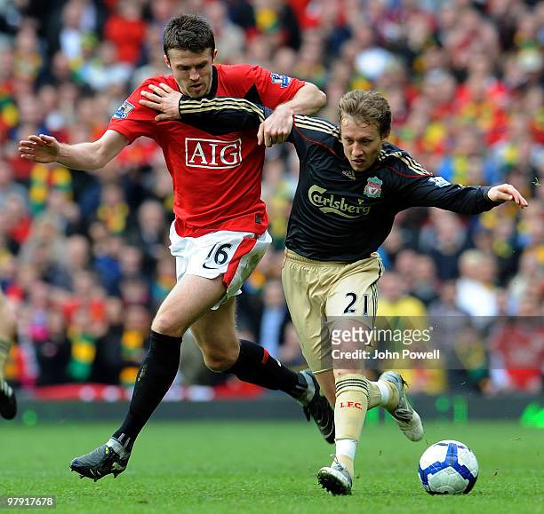 Lucas Leiva of Liverpool competes with Michael Carrick of Manchester United during the Barclays Premier League match between Manchester United and...