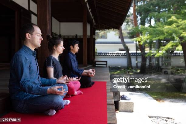 3 people meditating in temple garden - japan temple stock pictures, royalty-free photos & images