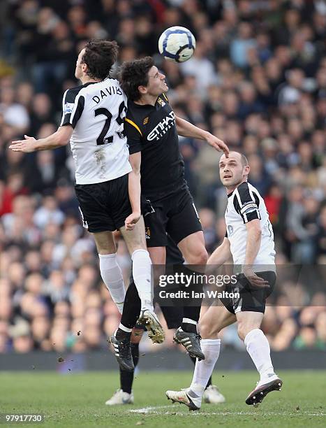 Simon Davies of Fulham and Gareth Barry of Manchester City jump for the ball as Danny Murphy of Fulham looks on during the Barclays Premier League...