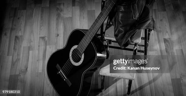 black acoustic guitar and leather jacket - kangan stock pictures, royalty-free photos & images