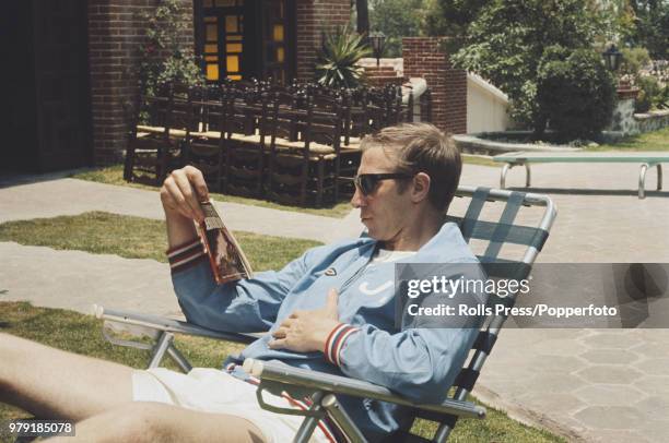 English footballer Jack Charlton of the England national football team squad relaxes with a 'Hondo' western paperback book in the grounds of the...