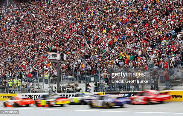 Joey Logano, driver of the Home Depot Toyota, and Kurt Busch, driver of the Miller Lite Dodge, lead the field to the green flag to start the NASCAR...