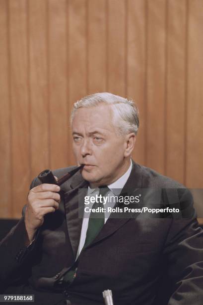 British Labour Party politician and Prime Minister of the United Kingdom, Harold Wilson pictured smoking a pipe at an election campaign press...