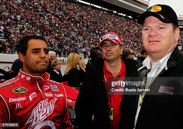 Juan Pablo Montoya, driver of the Target Chevrolet, stands on the grid with a crew member and Team owner Chip Ganassi prior to the NASCAR Sprint Cup...