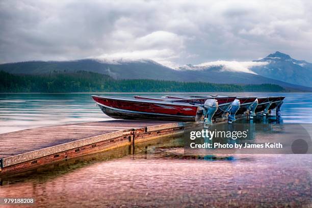 a row of boats lie on a pier awaiting a new day. - buitenboordmotor stockfoto's en -beelden