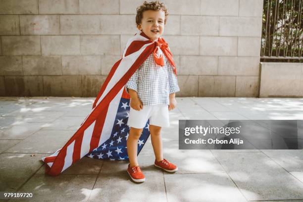 boy walking with american flag - american flag small stock pictures, royalty-free photos & images
