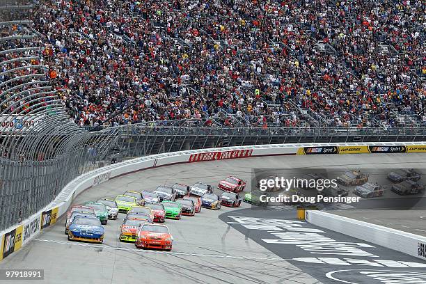 Joey Logano, driver of the Home Depot Toyota, and Kurt Busch, driver of the Miller Lite Dodge, lead the field to the green flag to start the NASCAR...