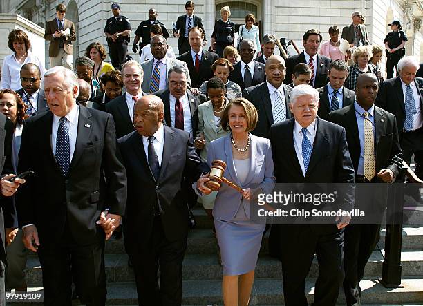 Speaker of the House Rep. Nancy Pelosi carries the gavel that was used when Medicare was passed while marching with Rep. John Lewis , Majority Leader...