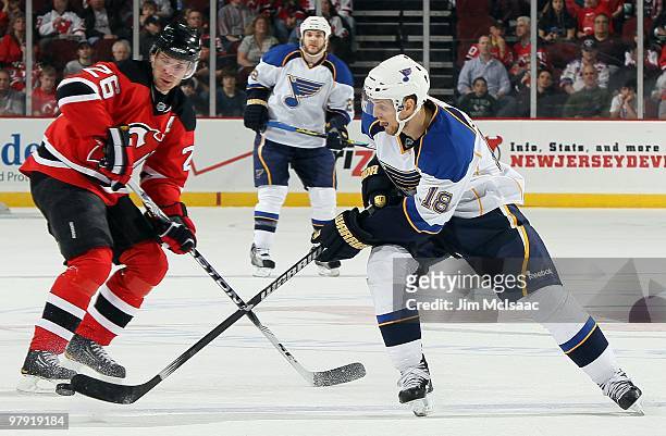 Jay McClement of the St. Louis Blues plays the puck against Patrik Elias of the New Jersey Devils at the Prudential Center on March 20, 2010 in...