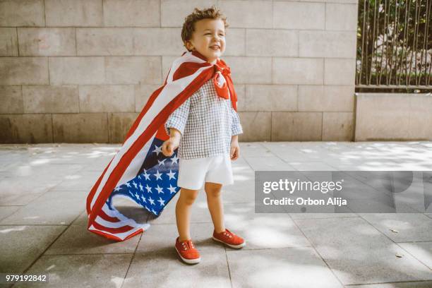 boy walking with american flag - american flag small stock pictures, royalty-free photos & images