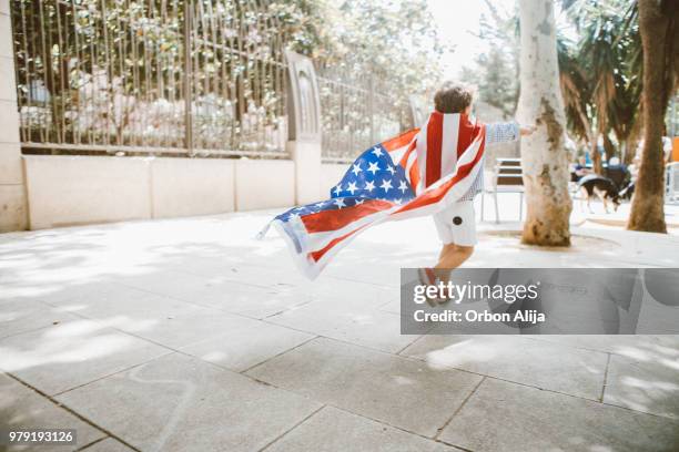 boy walking with american flag - american flag small stock pictures, royalty-free photos & images