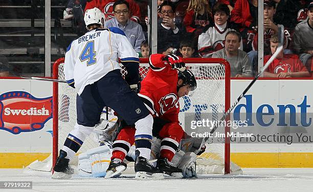 Eric Brewer of the St. Louis Blues defends against Jamie Langenbrunner of the New Jersey Devils at the Prudential Center on March 20, 2010 in Newark,...