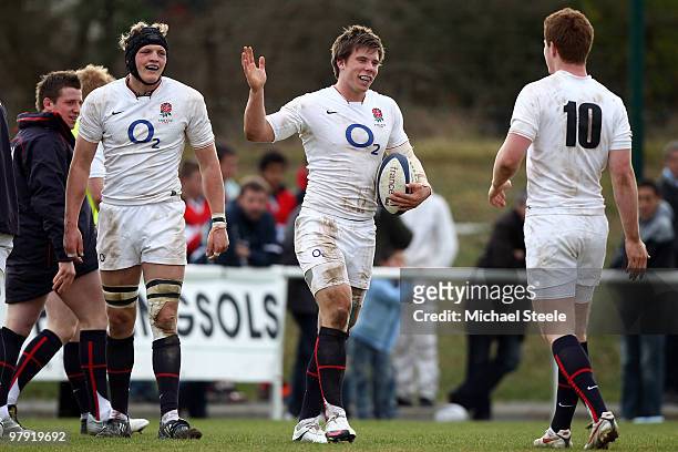 Sam Smith celebrates scoring a try with England team mates Rory Clegg and Jamie Gibson during the France U20's v England U20's match at the Stade du...