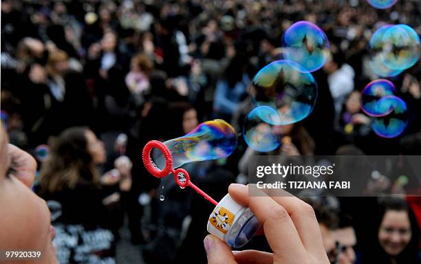 Young woman makes soap bubbles in the air during a flash mob at Piazza del Popolo in central Rome on March 21, 2010 to mark the first day of Spring....