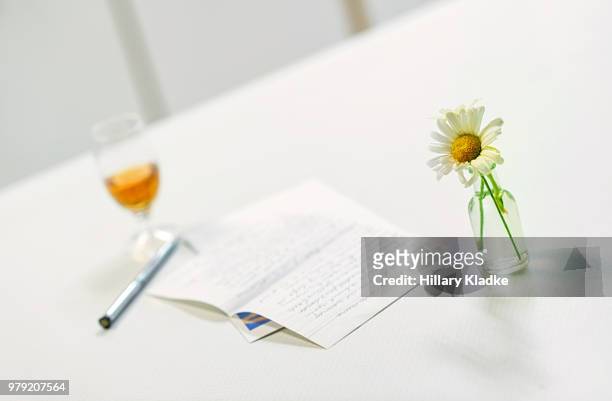 flowers in a vase with a letter and wine - paperweight stock pictures, royalty-free photos & images